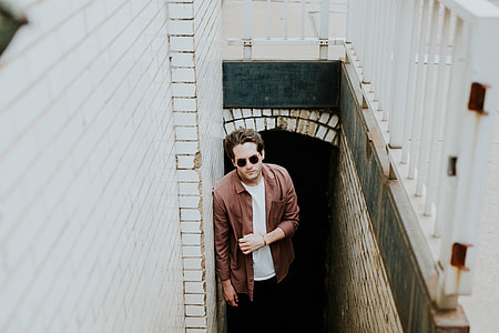 man wearing brown sport shirt standing on stairs at daytime thumbnail