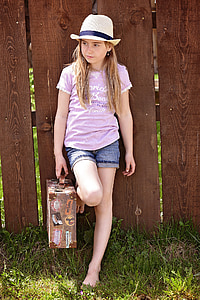 girl leaning on brown wooden wall thumbnail