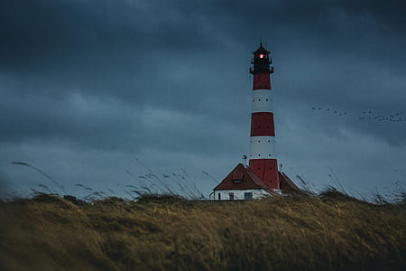 red and white lighthouse under gray sky thumbnail