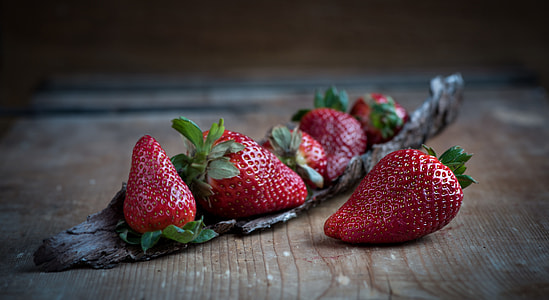 close up photo of strawberries on brown wooden table thumbnail