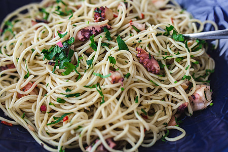 Fancy dinner with seafood pasta, crayfish and red wine by the table decorated with roses thumbnail