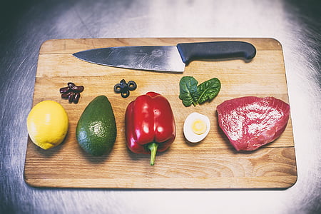 red bell pepper, raw meat, fruits, and black handled knife on chopping board thumbnail