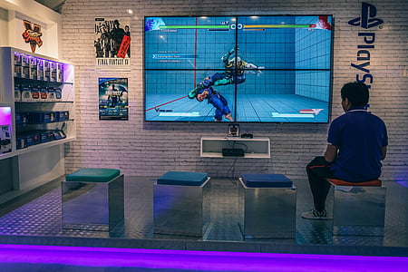 man sitting on chair while playing playstation game thumbnail