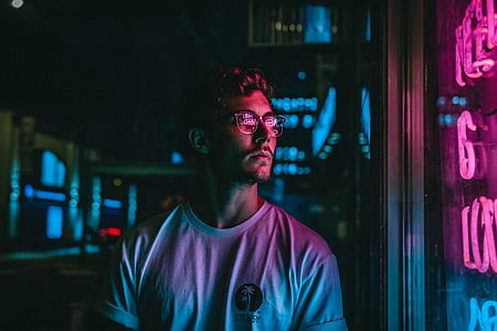 man standing beside neon signage thumbnail