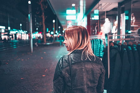 woman wearing jacket standing near clothes rack thumbnail
