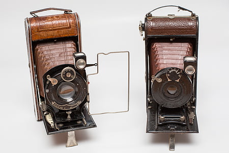 two brown folding cameras on white surface thumbnail