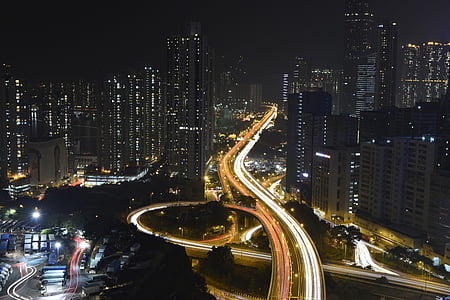 time lapse photography of road near buildings during night time thumbnail