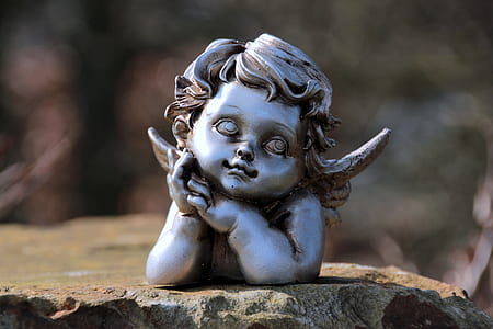 gray steel cherub mini figure on brown rock thumbnail
