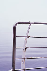 closeup photography of railings near calm body of water at daytime thumbnail