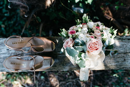pair of women's brown leather heels beside bouquet on grey plank thumbnail