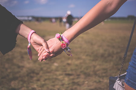 two person holding hands standing on grass field thumbnail
