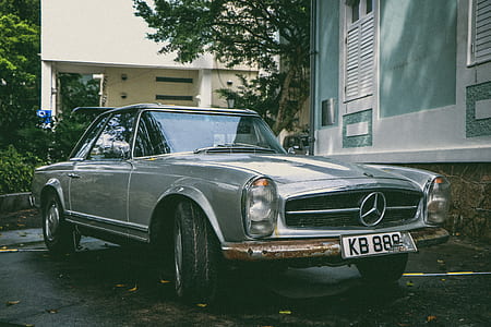 gray Mercedes-Benz coupe parked beside house thumbnail