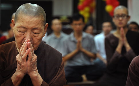 selective photo of woman praying inside room thumbnail