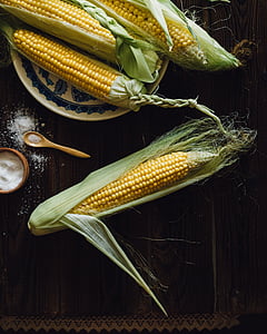 four corns cob on brown surface thumbnail