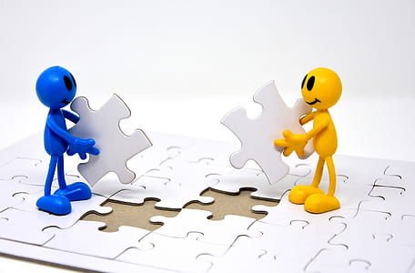 two blue and yellow figure holding puzzle thumbnail