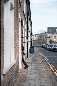 person carrying ladder near road thumbnail