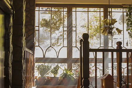 brown wooden balustrade with light filtering through glass windows in background during daytime thumbnail