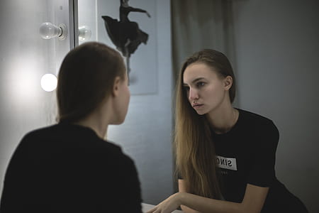 woman staring at mirror thumbnail