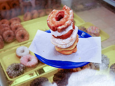 A bunch of donuts stacked on a blue plate. thumbnail