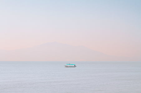 white and teal boat in the middle of ocean thumbnail