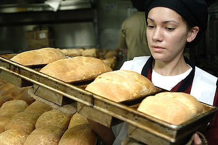 woman carrying a tray of baked breads thumbnail