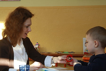 woman wearing brown cardigan sitting facing on boy wearing black long-sleeved shirt thumbnail