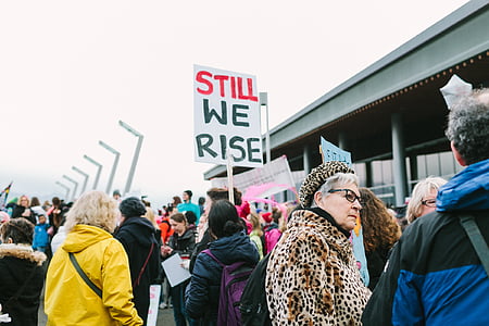woman holding still we rise banner thumbnail
