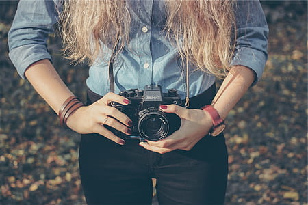 woman holding black DSLR camera during daytime thumbnail