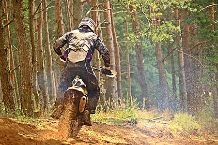 man riding motorcycle beside trees during daytime thumbnail