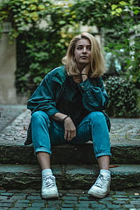 woman sitting while her hand on her neck looking at left side thumbnail
