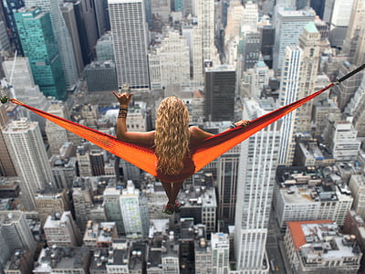 woman on orange hammock on top of high-rise building thumbnail