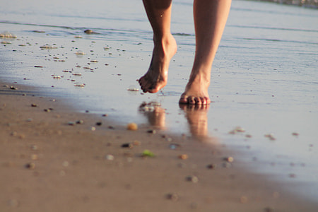 person walking on seashore during daytime thumbnail