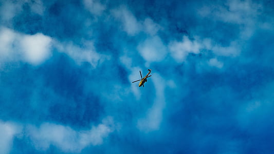 helicopter flying under clouds thumbnail