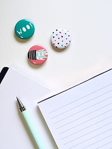 pen and writing paper on white surface with multicolored pebbles thumbnail