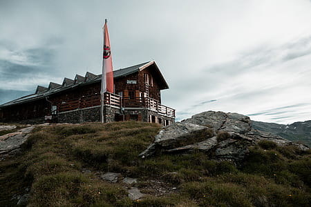 brown wooden house under cloudy sky thumbnail
