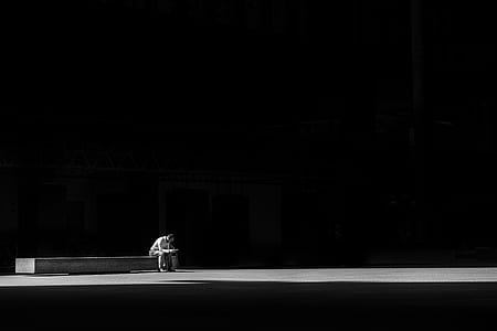 grayscale photo of man sitting thumbnail