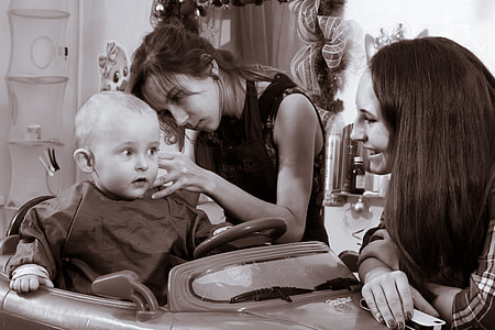 grayscale photo of woman touching baby on ride-on car toy thumbnail
