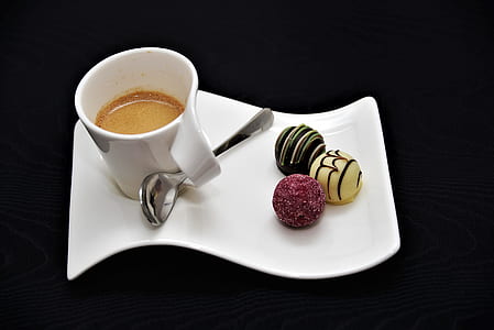 white ceramic teacup with coffee and pastries on top of ceramic dish thumbnail