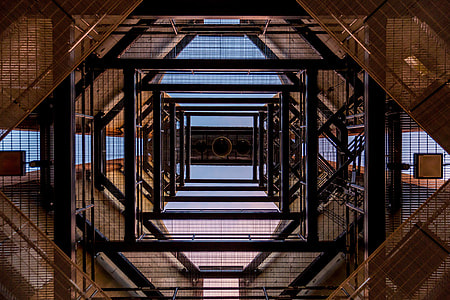 low angle photography of black and brown metal scaffolding frames during daytime thumbnail