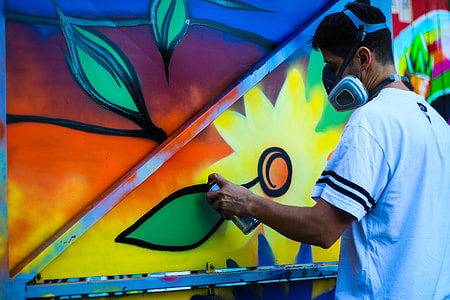 man coloring wall with yellow paint wearing mask thumbnail