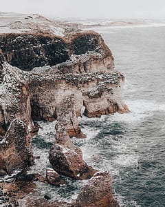 brown and gray rock near the body of water during daytime thumbnail