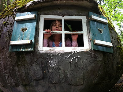 girl inside black house looking through the window thumbnail