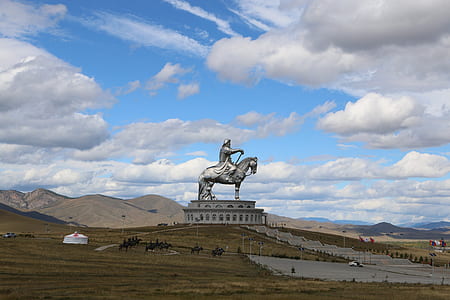 man riding horse statue near brown mountains landscape photography at daytime thumbnail