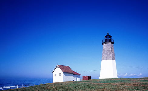 photo of house and lighthouse near body of water thumbnail