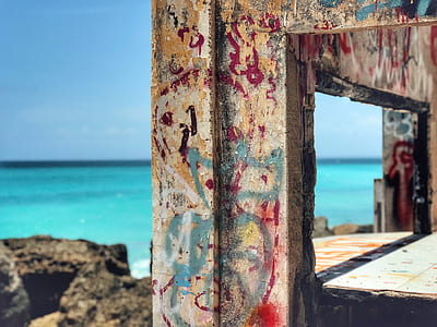 multicolored painted wooden frame near green sea thumbnail