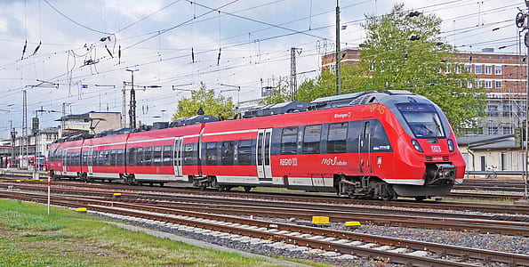red train traveling near town thumbnail