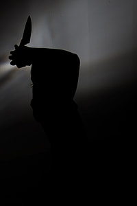 silhouette photo of person holding knife thumbnail