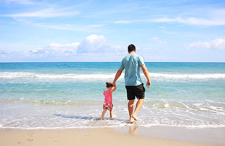 man holding girl beside seashore thumbnail