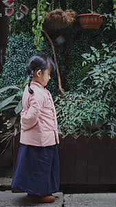 girl stands near green leaf plant during daytime thumbnail