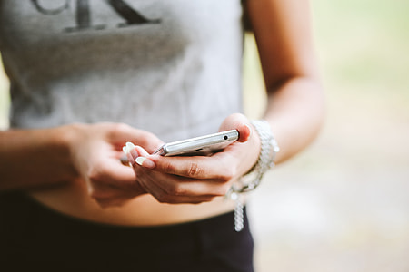 Young woman holding the white mobile phone thumbnail